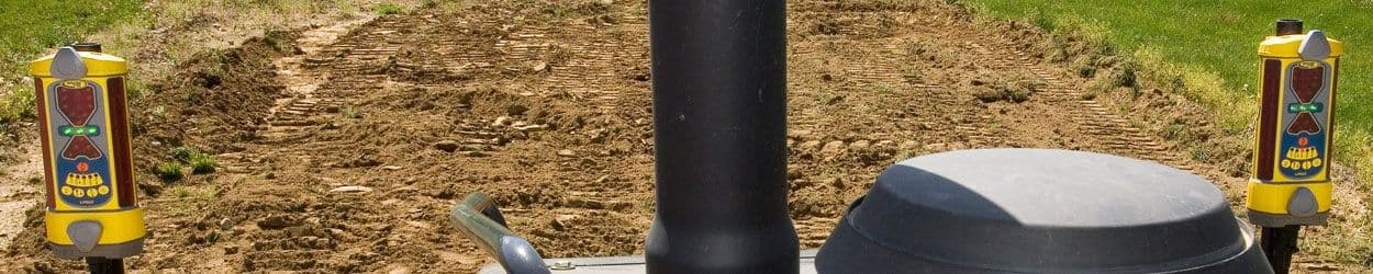Twee gele machineontvangers gemonteerd op een graafmachine voor nivellering van bouwterrein