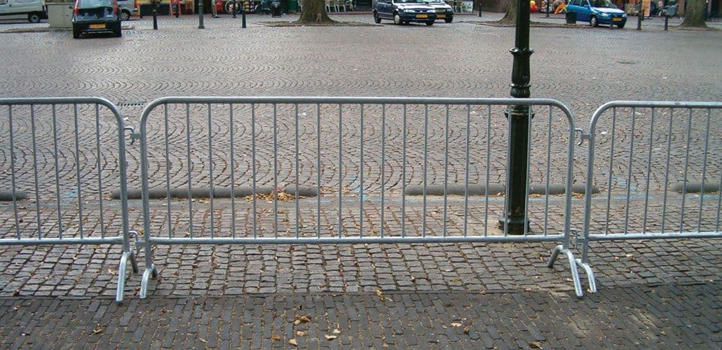 Een rij gekoppelde dranghekken op een plein