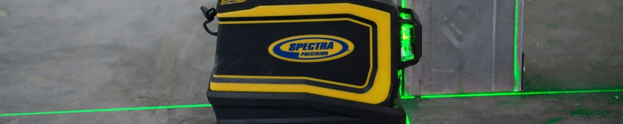 Spectra Precision lasertool projecteert groene lijnen op betonnen vloer en wand.