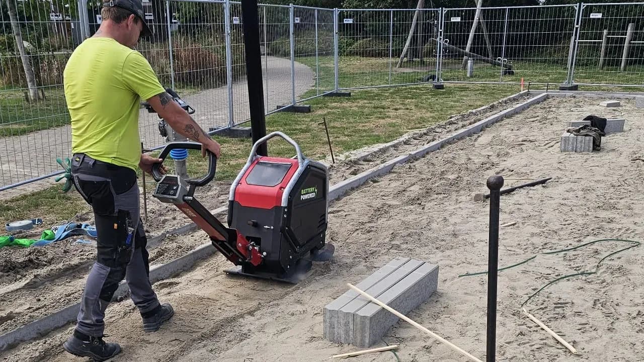 Persoon aan het werk met accu-trilplaat van Swepac