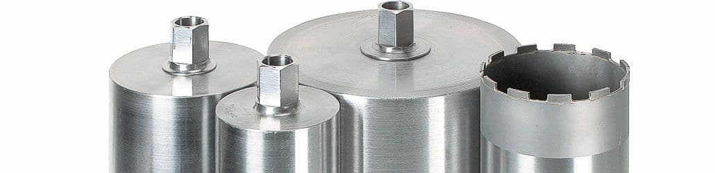 Close-up van vier metalen diamantboren in verschillende diameters, met zeskantaansluiting en segmentrand voor nat of droog boren in beton en steen.