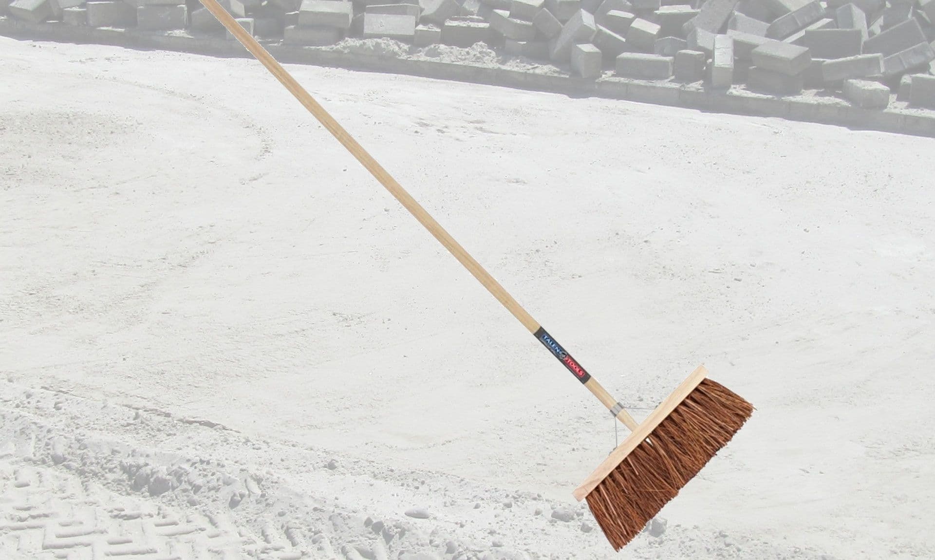 Straatbezem met zandbaan op de achtergrond