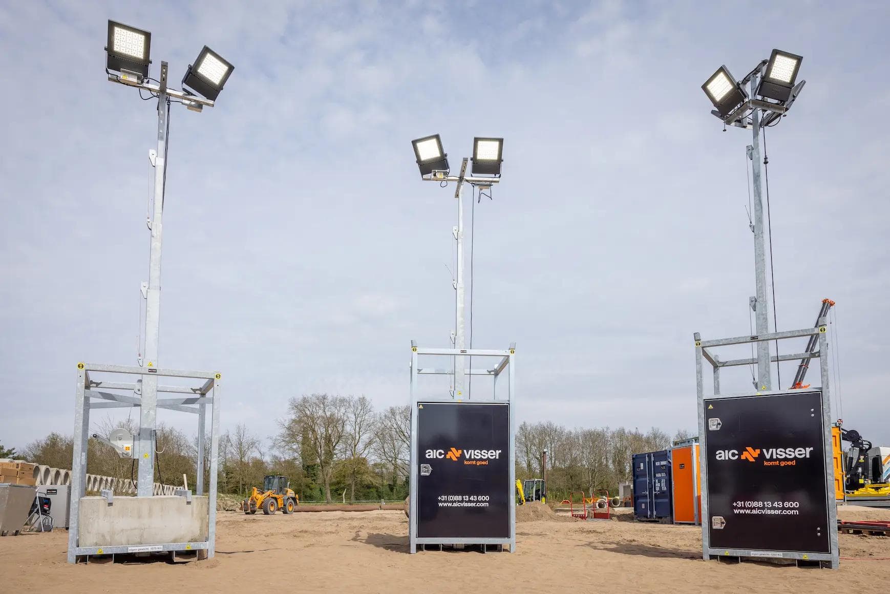 Drie mobiele lichtmasten met LED-schijnwerpers op een bouwterrein.