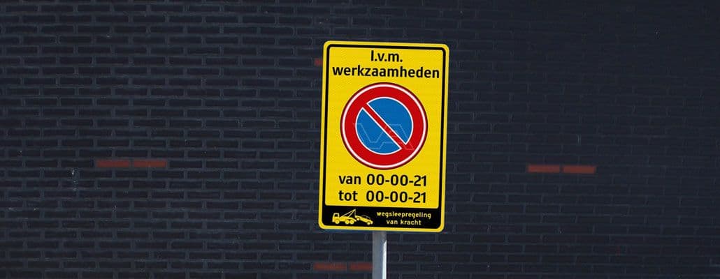 Tijdelijk verkeersbord met parkeerverbod in verband met werkzaamheden, met een wegsleepregeling van kracht. De voorbeelddata op het bord zijn ingevuld als 00-00-21.
