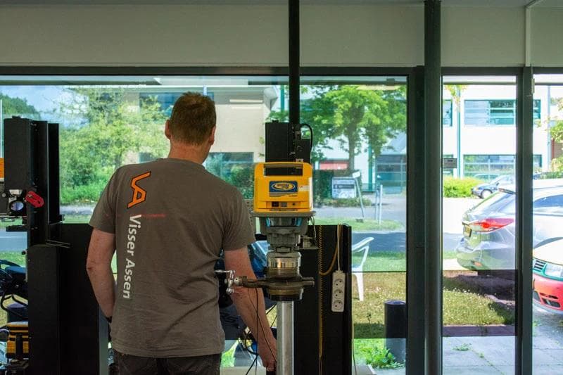 Een bouwlaser en een collega van ons met een Visser Assen shirt en het oude logo
